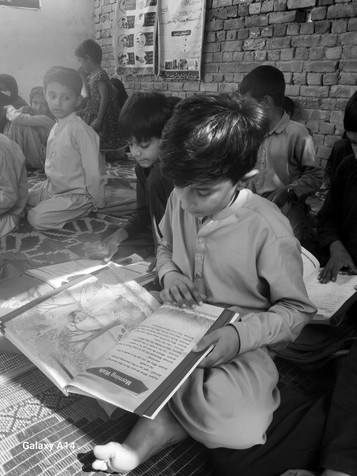 Children reading textbooks in a community classroom